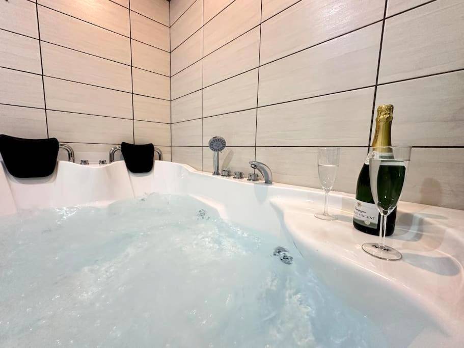 Baignoire balnéo avec bouteille de champagne - E Servagnat T3 luxe avec Sauna Jacuzzi et Hammam