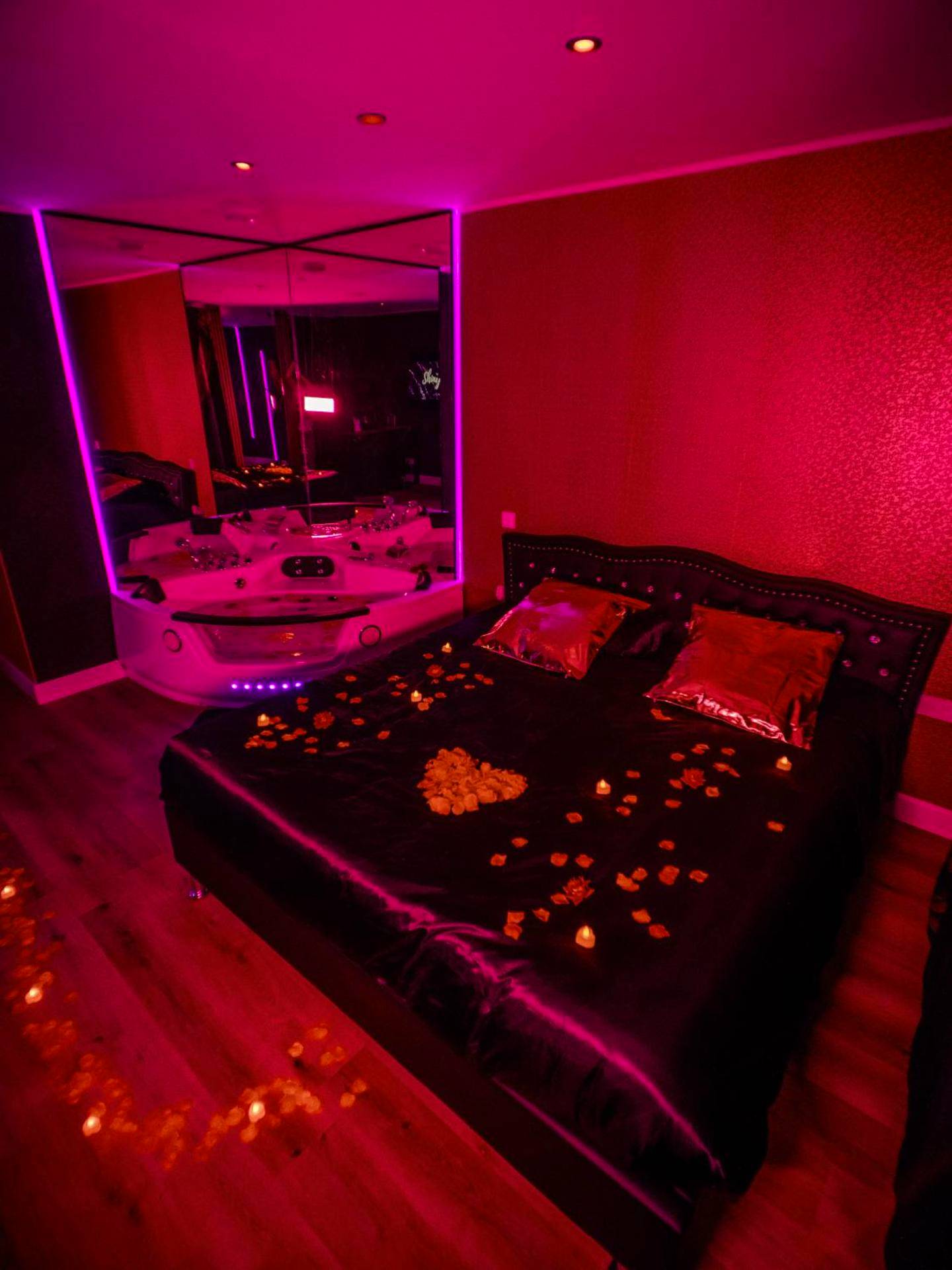Lit king size avec pétales et jacuzzi en fond - Shiny Cloud Love Room