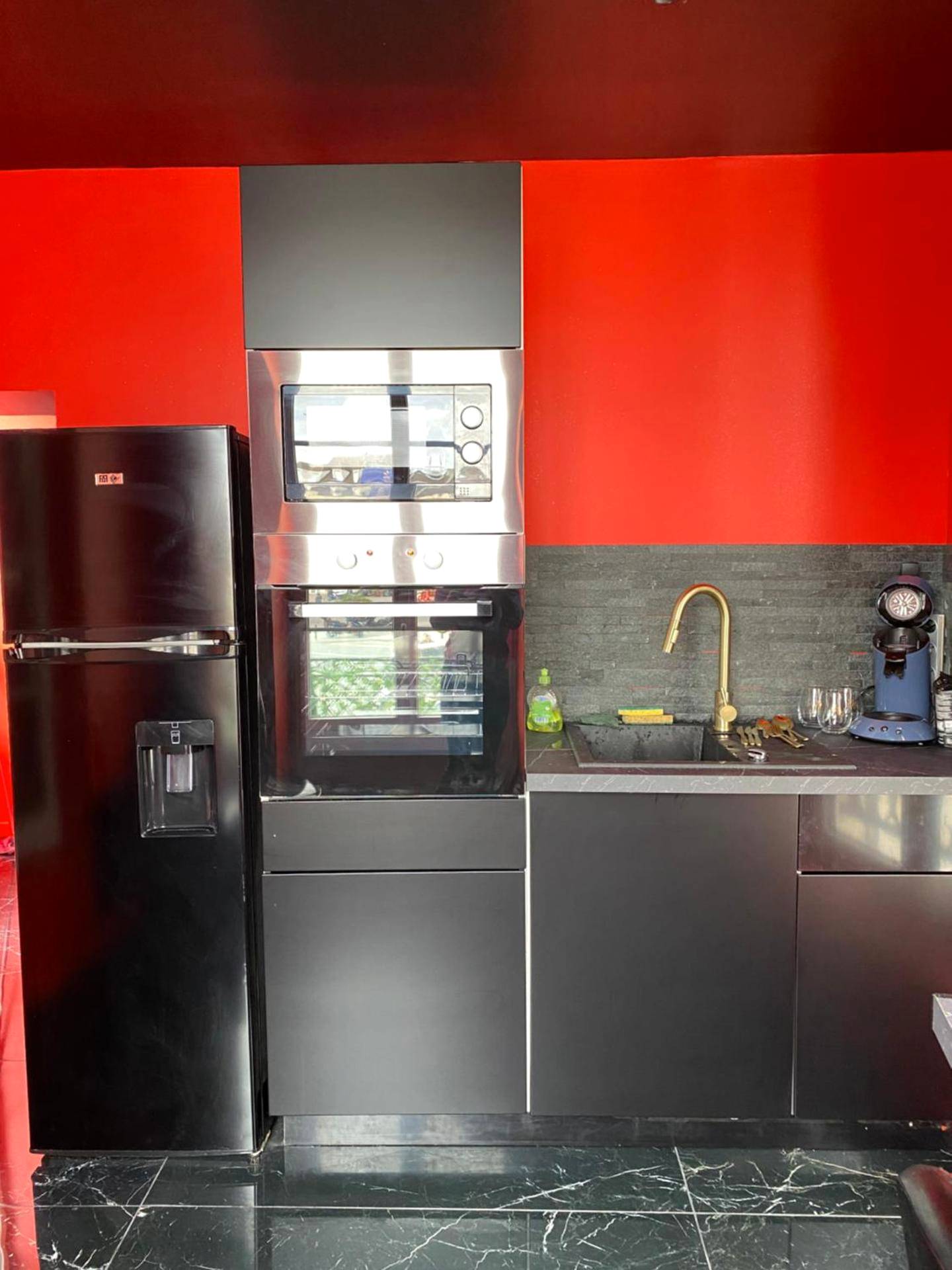 Cuisine équipée avec électroménager noir - Le souffle de l’amour