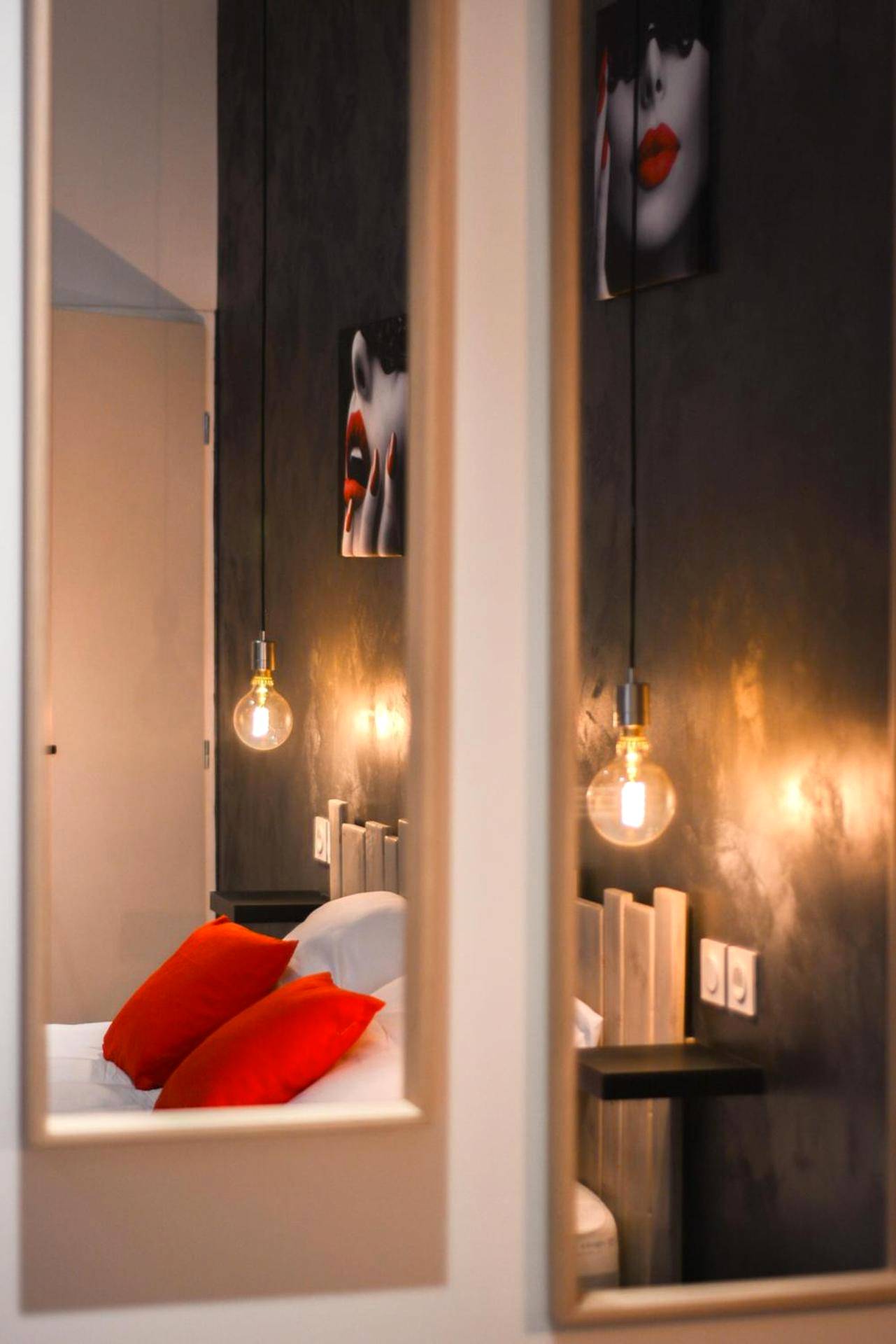 Miroirs verticaux reflétant le lit et lampes - Sous le Charme de Charles Sauna & Jacuzzi Nancy