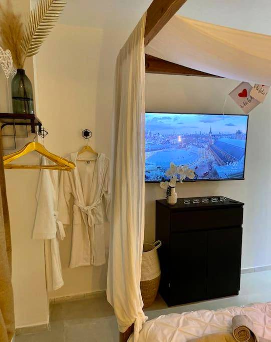 Peignoirs blancs et télévision face au lit - Appartement - Spa