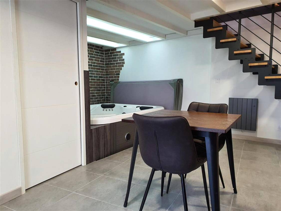 Espace repas et jacuzzi privatif intérieur - Love room avec spa privatif