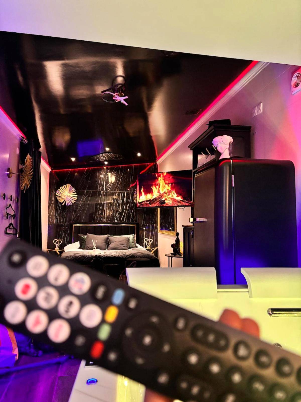 Vue d'ensemble de la suite avec TV cheminée - Love Room élégante spa privatif et extérieur cosy