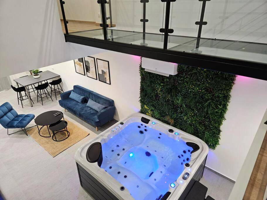 Jacuzzi privatif et salon avec mur végétal - Love Room Bar - le - Duc - Spa des ducs loft 1