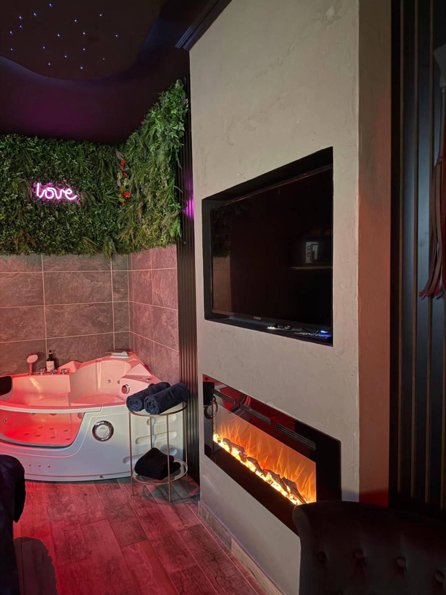 Espace détente avec TV et cheminée moderne - Love Room avec spa