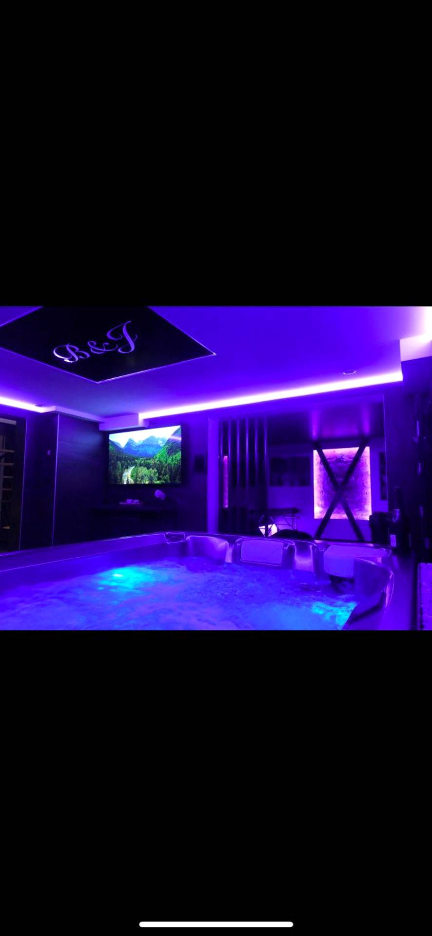 Jacuzzi privatif sous un éclairage néon violet - Love Room Metz - Loveroom Metz Spa Privatif