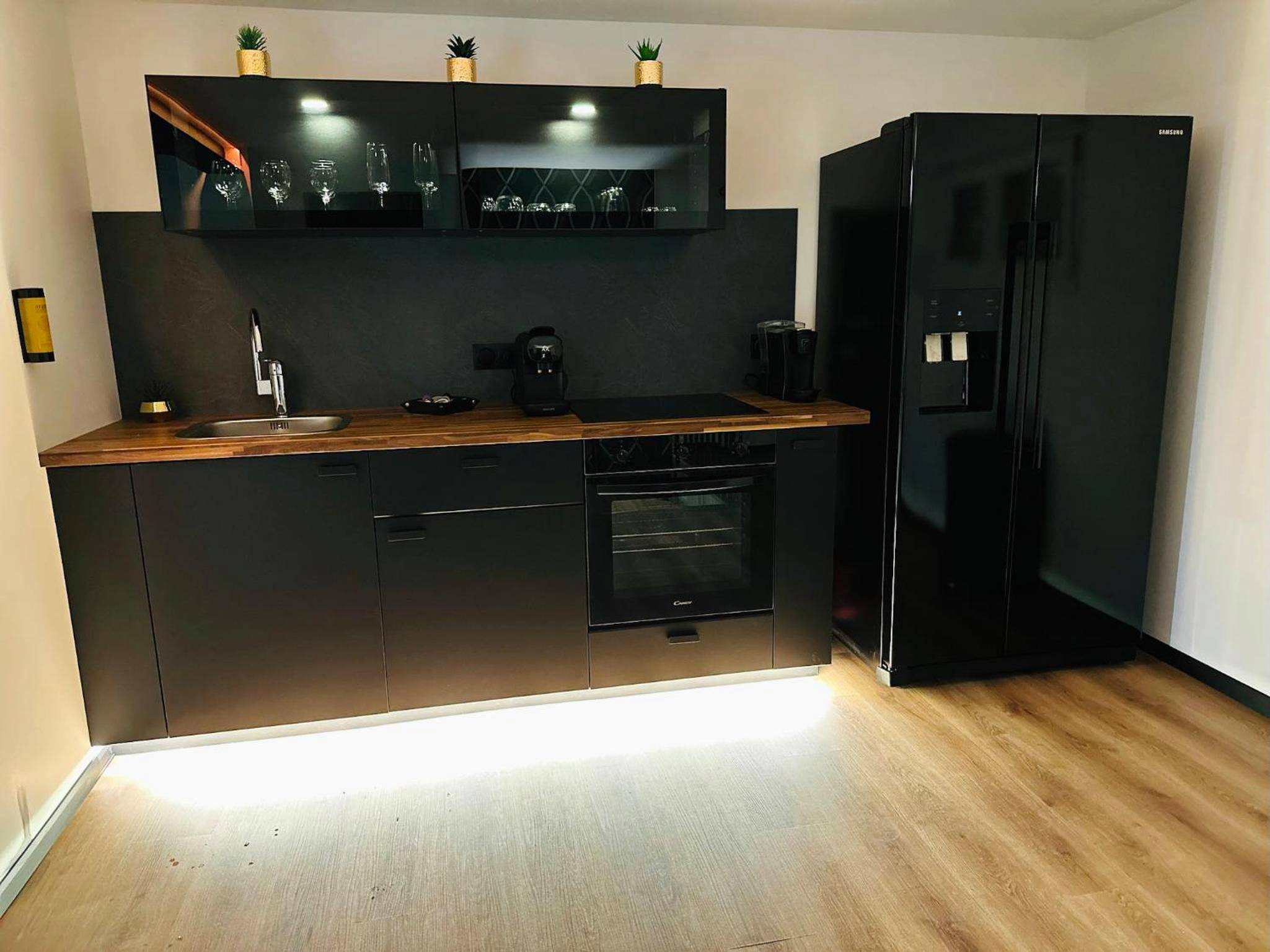 Cuisine équipée noire avec grand réfrigérateur - Loveroom Metz Spa Privatif