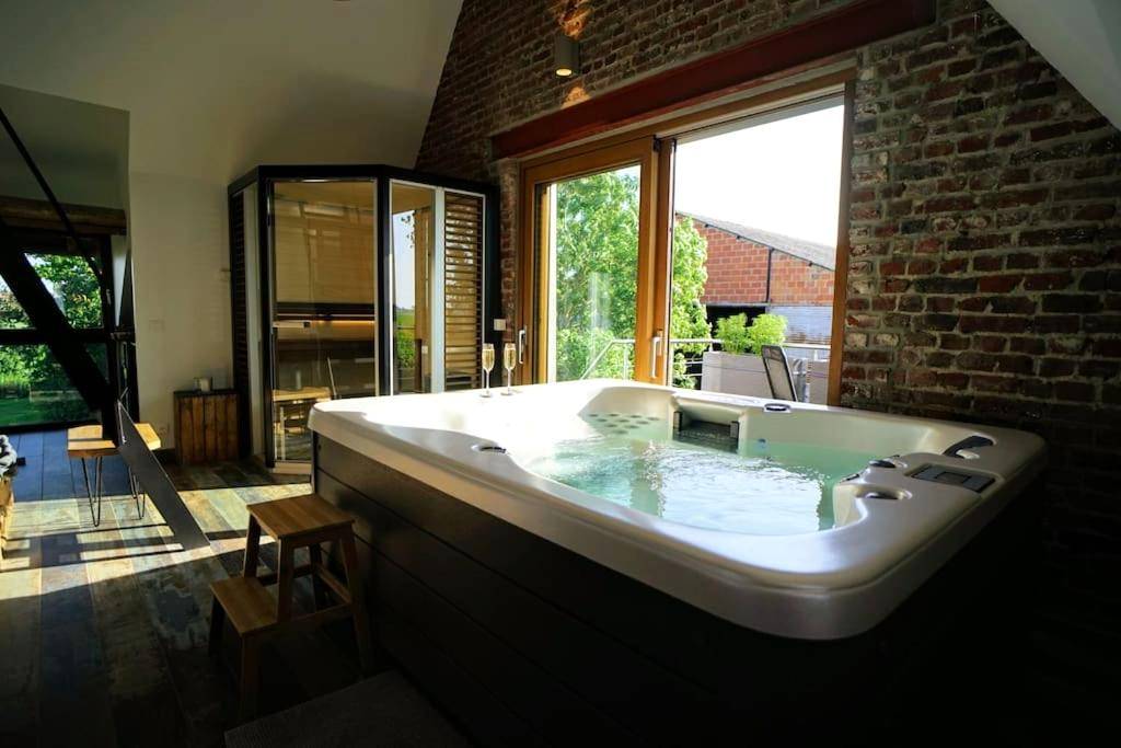 Jacuzzi privatif face à une baie vitrée - Spa privatif à la ferme - Haut de gamme - Atypique