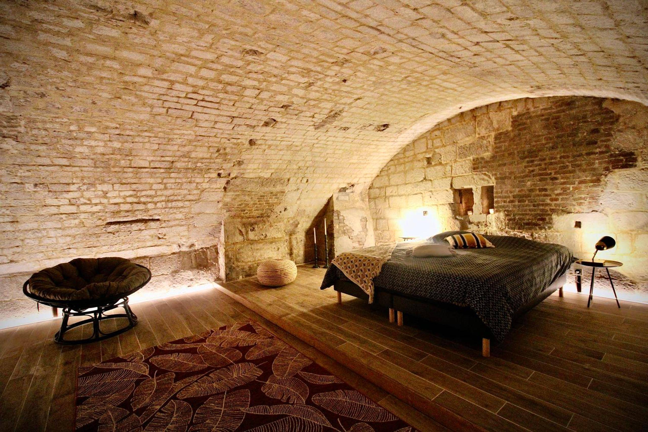 Lit double dans une chambre voûtée en pierre - Spa Gaalor***** - Jacuzzi & Sauna à Rouen