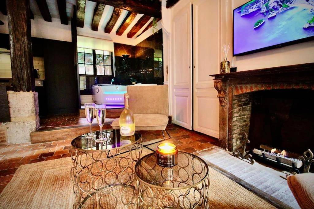 Salon avec cheminée et bouteille de champagne - Love Room Rouen - Le Spa Gustave - Sauna, Jacuzzi & Terrasse à Rouen