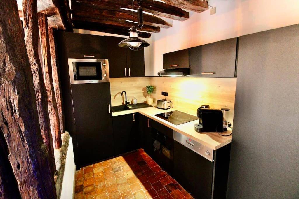 Cuisine équipée moderne avec meubles noirs - Le Spa Gustave - Sauna, Jacuzzi & Terrasse à Rouen