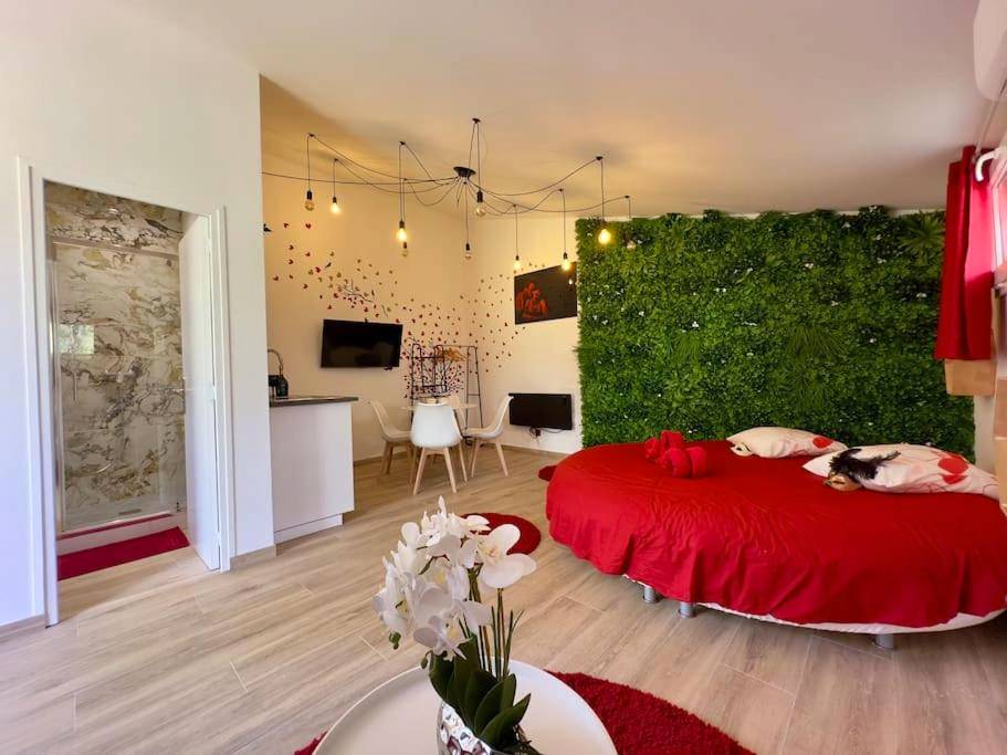 Lit rond rouge et mur végétal - SPA JACUZZI et table massage