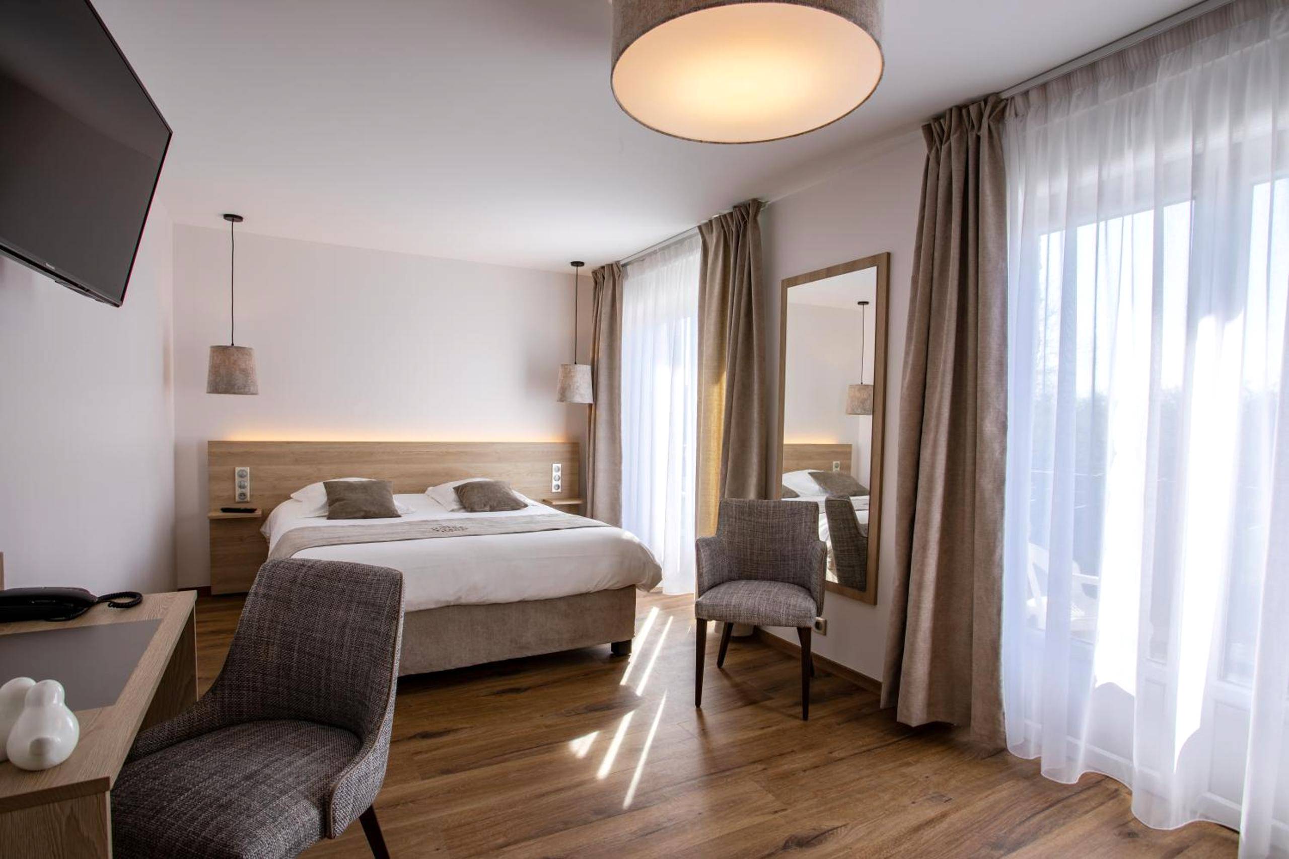 Chambre lumineuse avec parquet et grand miroir - Hôtel SPA du Lac de Madine - Maison DRAPIER