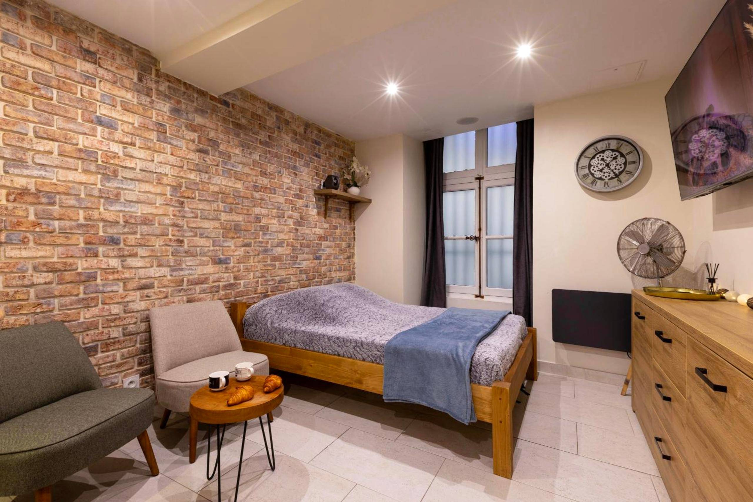 Chambre avec mur en briques et lit double - Au Spa de LLEA