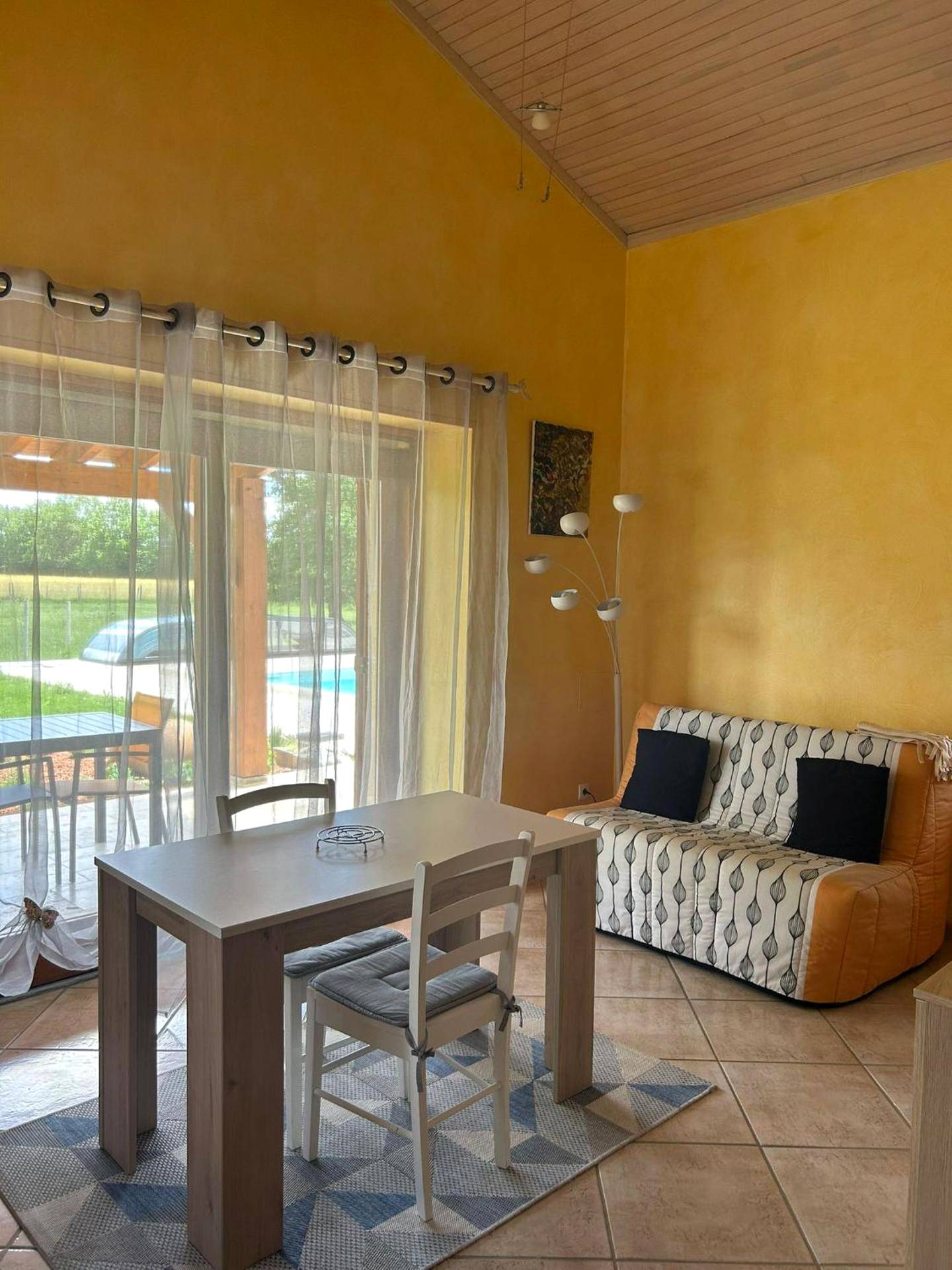 Coin salon et repas lumineux avec canapé - Le petit SPA dans le Quercy