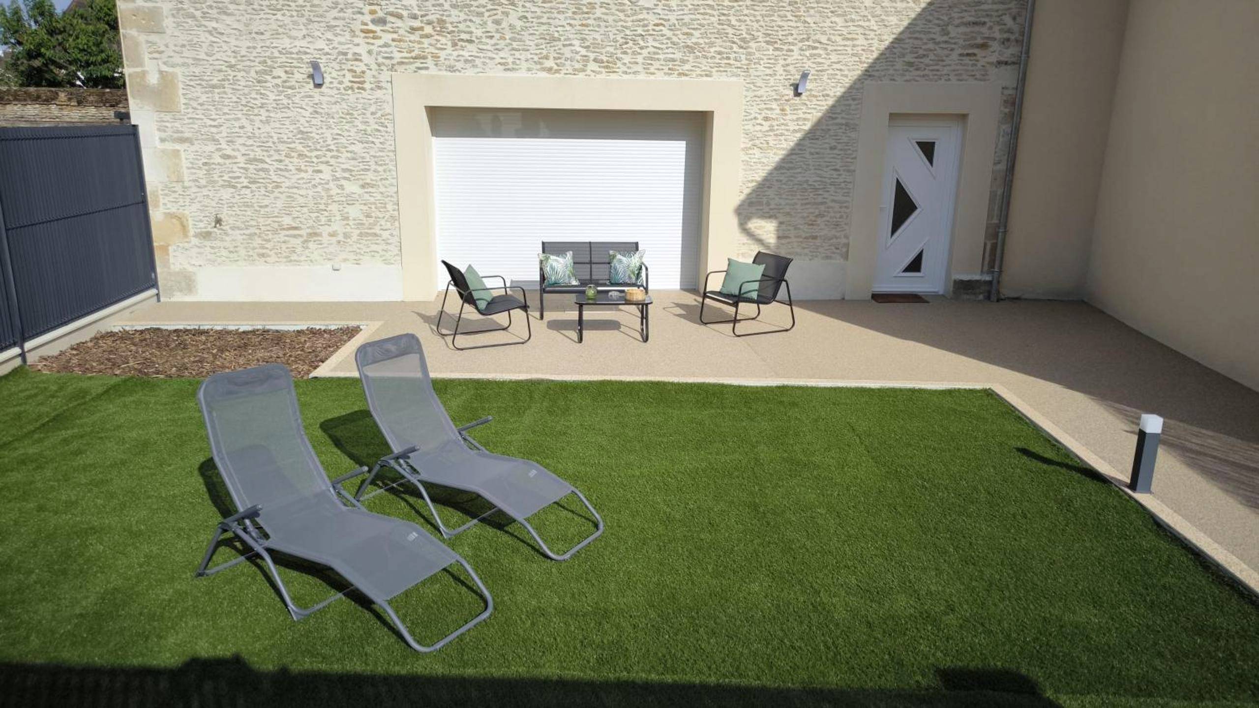 Terrasse aménagée avec transats et jardin - Le Spa SAJ