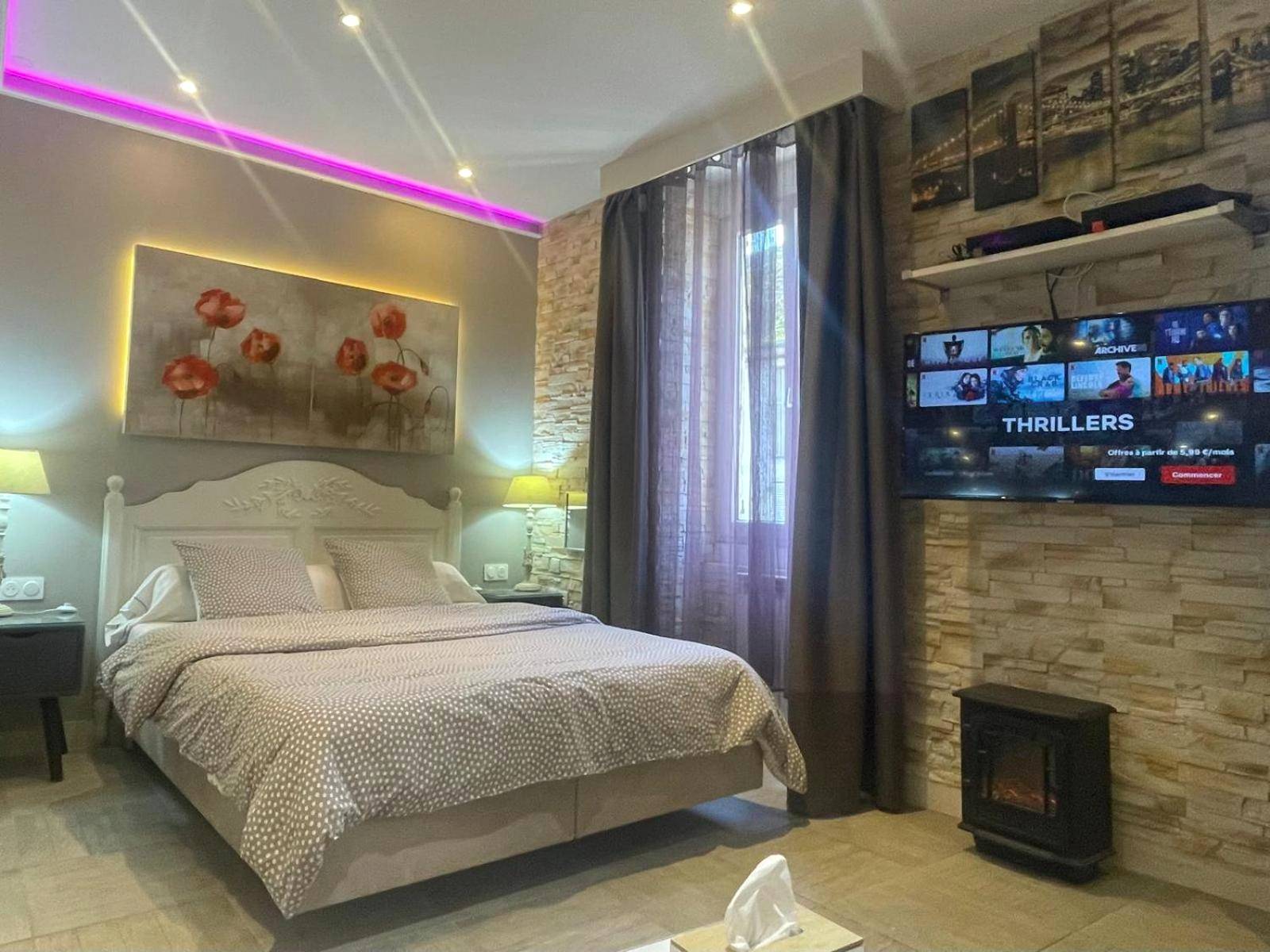 Chambre avec lit double et éclairage néon rose - Appart' Spa et Sauna Privatif Au Cœur De Beaune