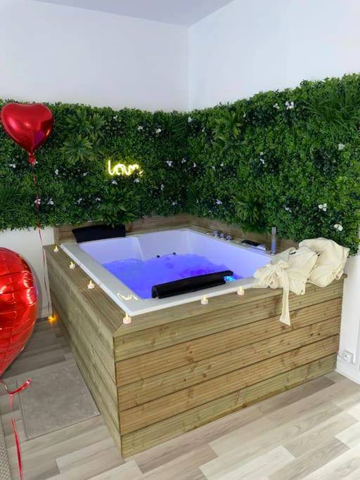 Jacuzzi privatif avec mur végétal et néon Love - Love Room L'Horme - Appartement avec Spa et Sauna