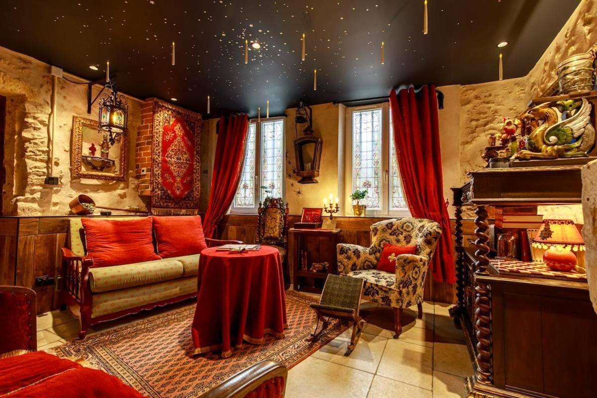 Salon thématique avec fauteuils et rideaux rouges - Le Spa du Sorcier