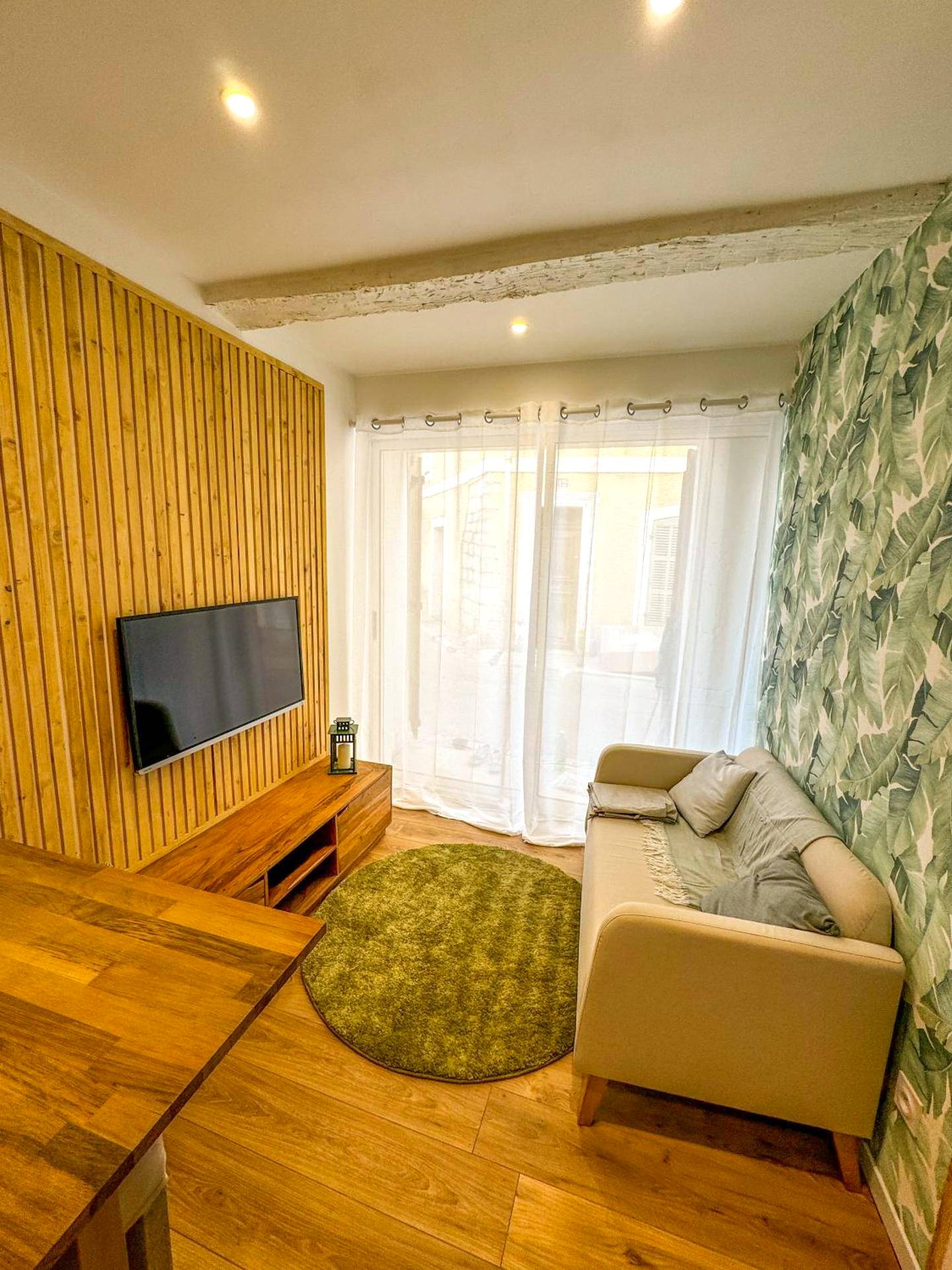 Salon avec canapé, télévision et papier peint jungle - Intimiste retraite de Sainte - Logement entier Le Spa des Voutes...