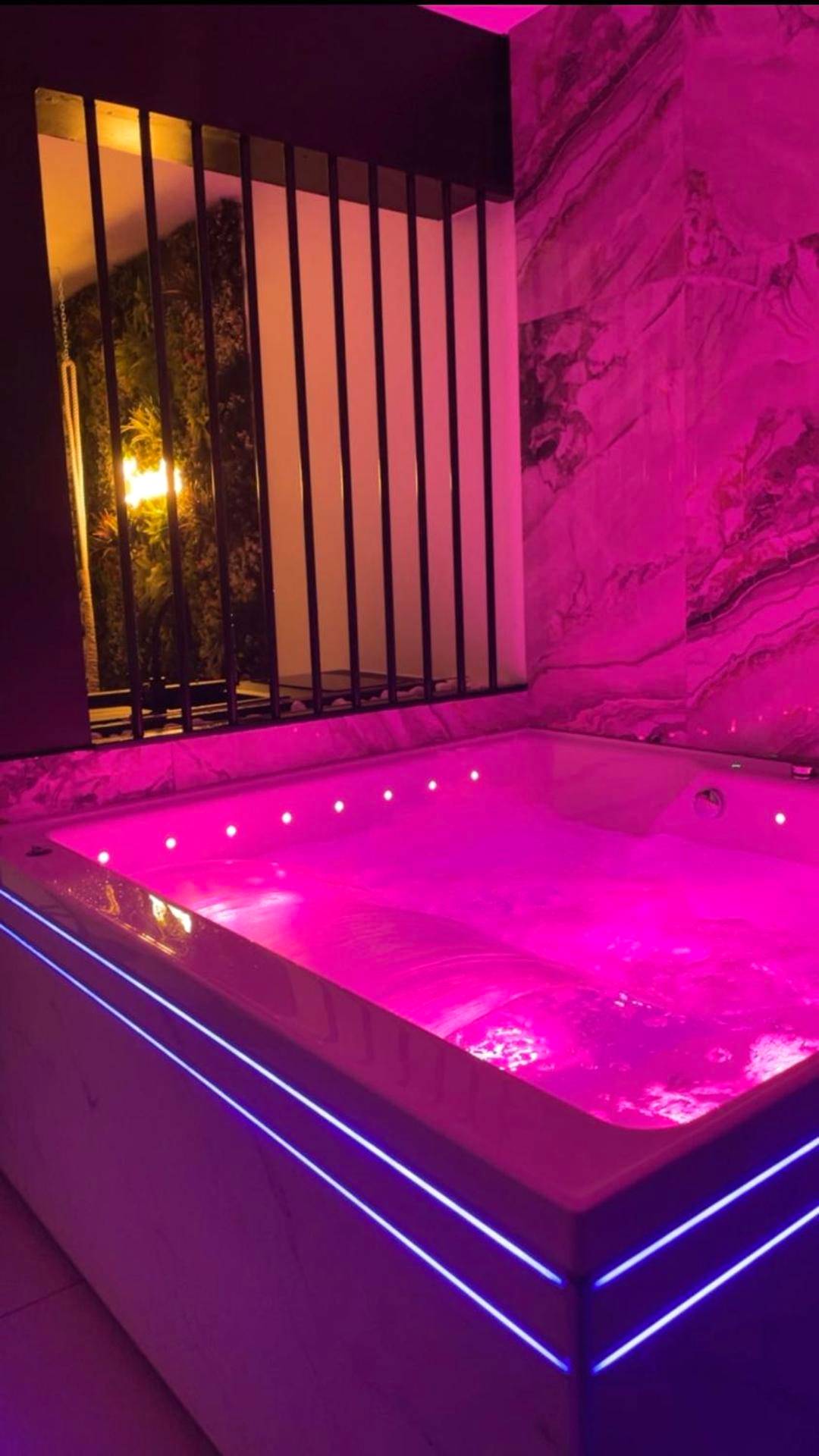 Jacuzzi privatif avec éclairage rose - Love Room Le Creusot - Sparadise : Jacuzzi et Sauna