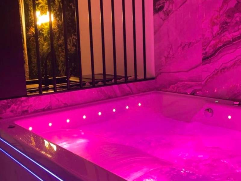 Jacuzzi privatif avec éclairage rose - Love Room Le Creusot - Sparadise : Jacuzzi et Sauna
