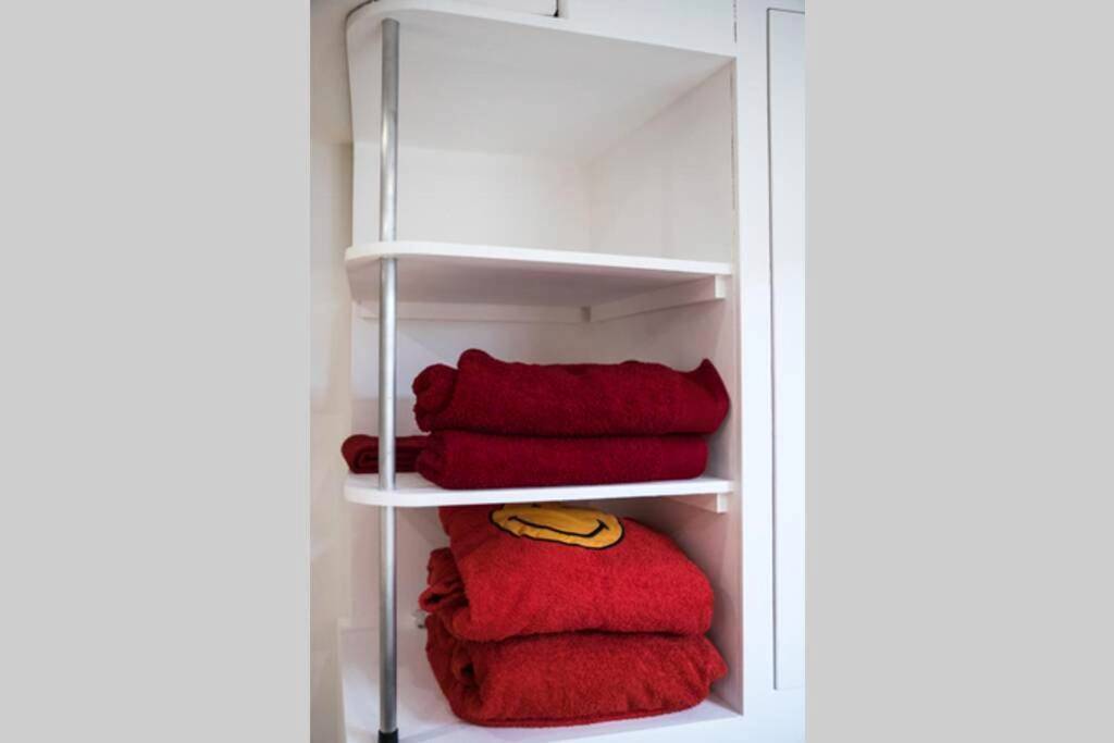 Serviettes et peignoirs rouges sur étagères - Les SPAS Insolites - Le SPA du Moulin
