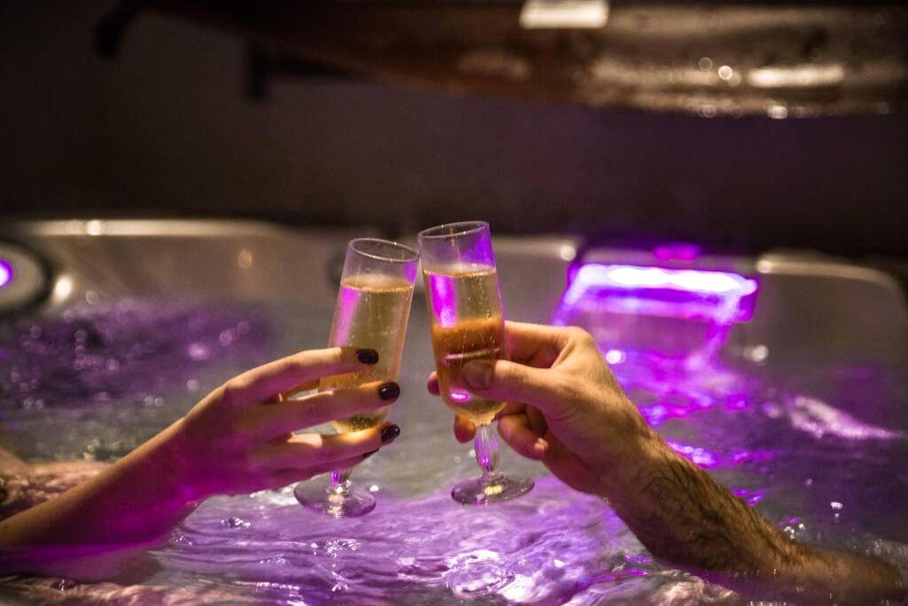 Trinquage au champagne dans un jacuzzi illuminé - Les SPAS Insolites - Le SPA du Moulin