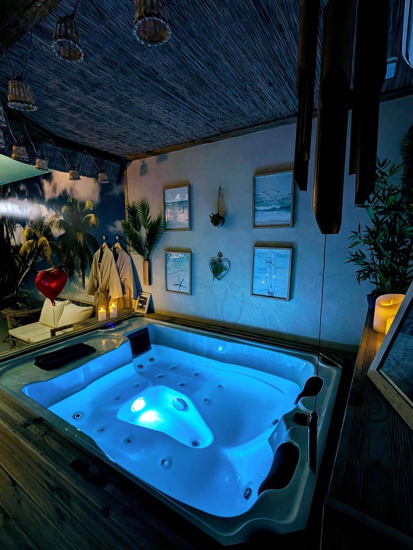 Jacuzzi privatif avec éclairage bleu et cadres - Love Room Le Grau - du - Roi - Les Spas de la Mer, Appart&Spa Aloha,...