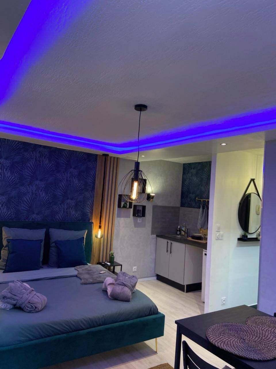 Chambre avec éclairage LED bleu et coin cuisine - Appartement La Splenzia SPA Jacuzzi wifi clim