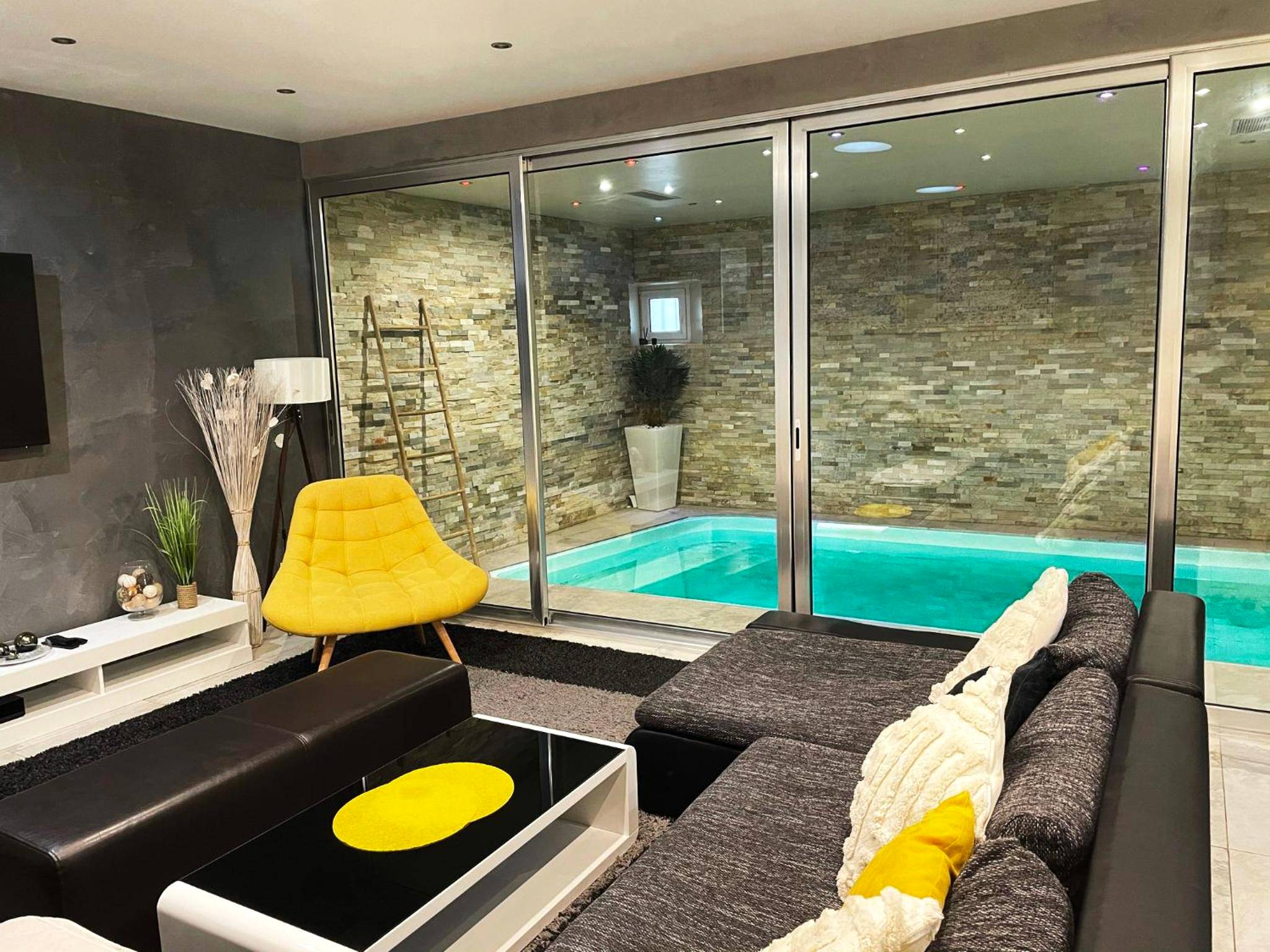 Salon moderne avec vue sur piscine intérieure - Love Room Mutzig - Appartement Standing piscine intérieur privatisée .
