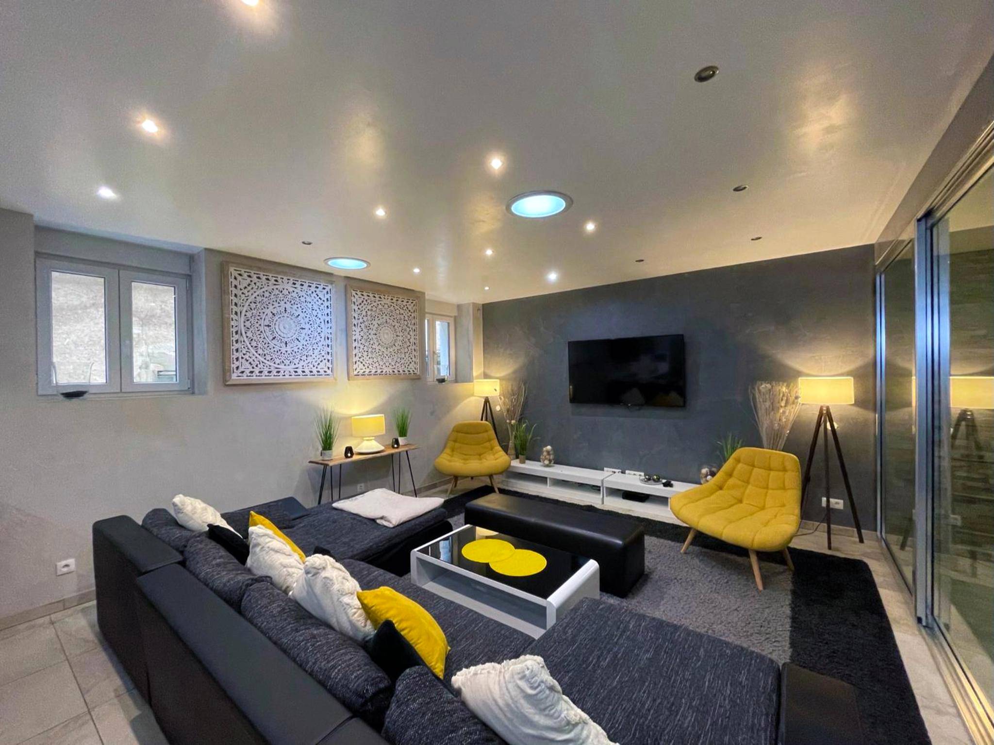 Espace salon avec canapé d'angle et fauteuils - Appartement Standing piscine intérieur privatisée .