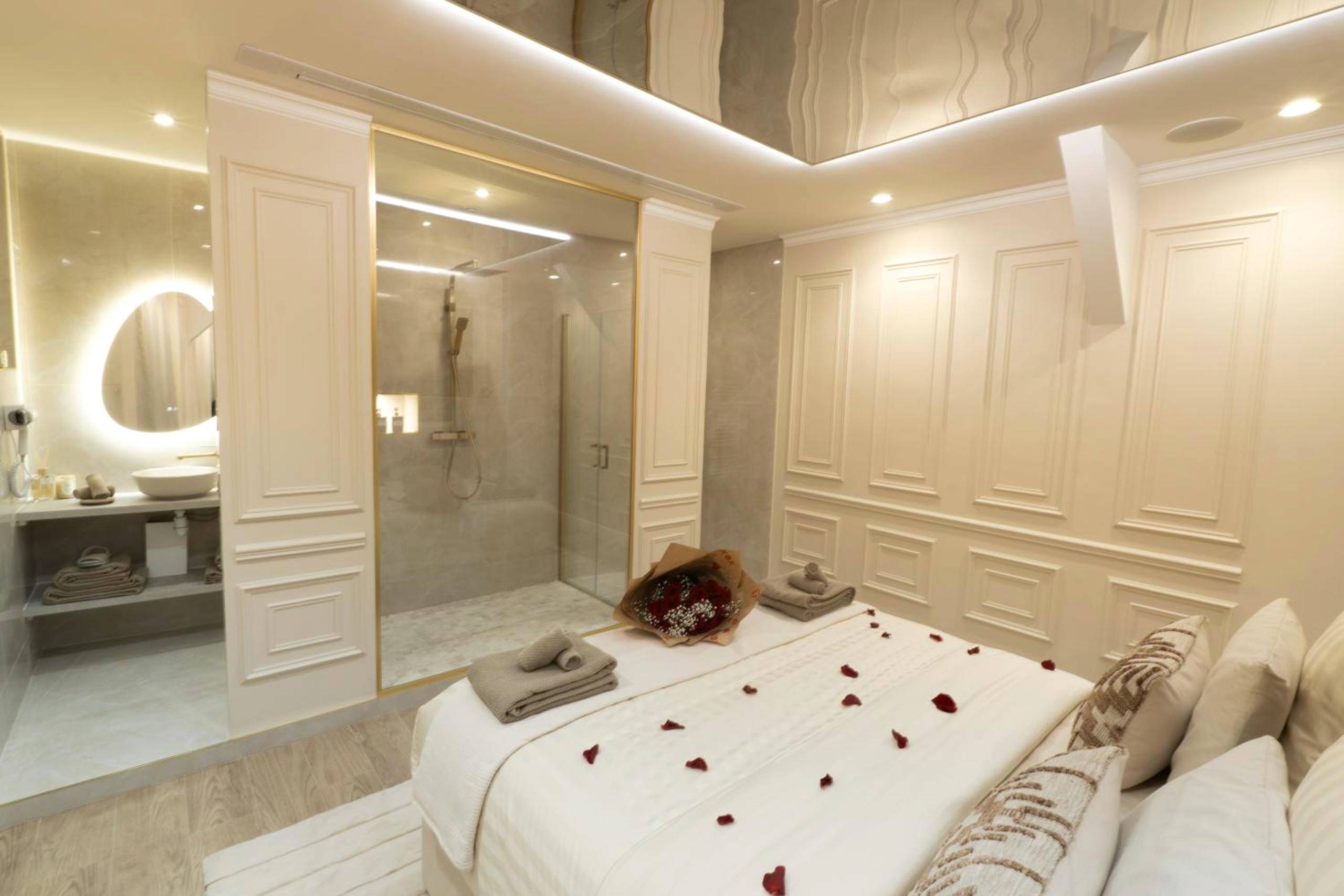 Lit king size décoré face à la douche vitrée - Stellar Suite