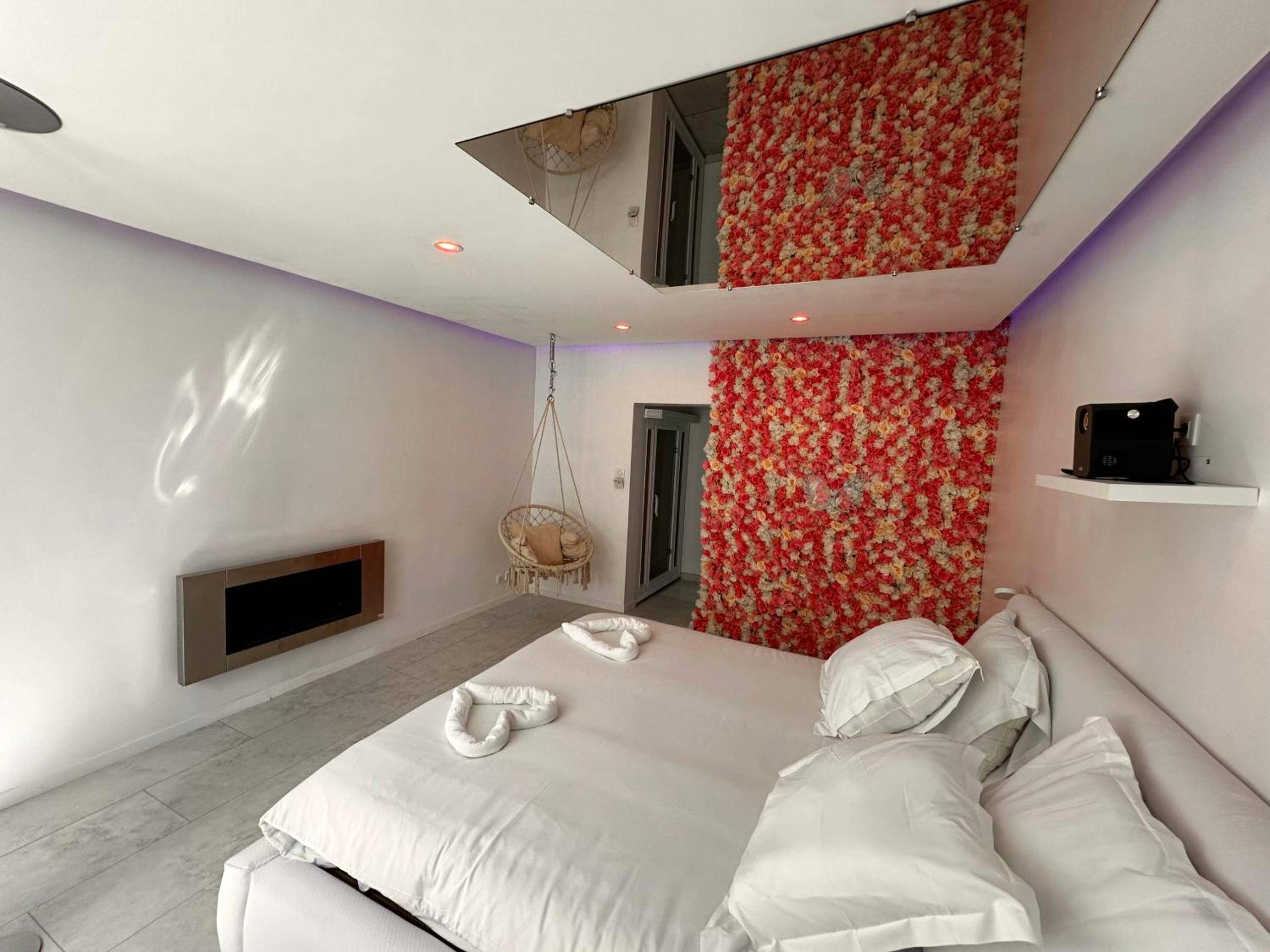 Lit king size sous miroir et mur de fleurs - Love Room Talange - Studio tout confort pour Amoureux, proche Metz