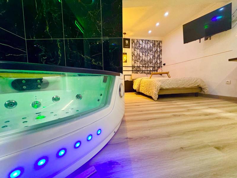 Jacuzzi privatif et lit double en arrière - plan - Love Room Évreux - Studio & Balnéo privatif