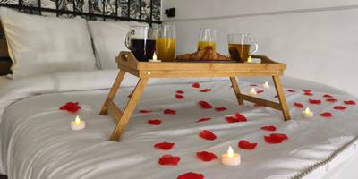 Pétales de roses et bougies sur lit blanc - Studio & Balnéo privatif
