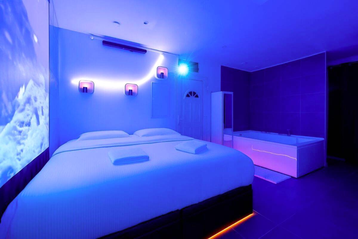 Lit double face au jacuzzi sous lumière bleue - Studio Immersif Jaccuzi & Cinéma Disney et Astérix
