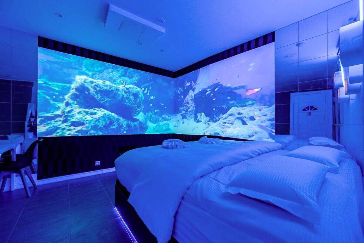 Lit king size et murs d'écrans panoramiques - Studio Immersif Jaccuzi & Cinéma Disney et Astérix