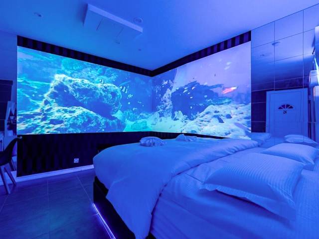 Lit king size et murs d'écrans panoramiques - Studio Immersif Jaccuzi & Cinéma Disney et Astérix