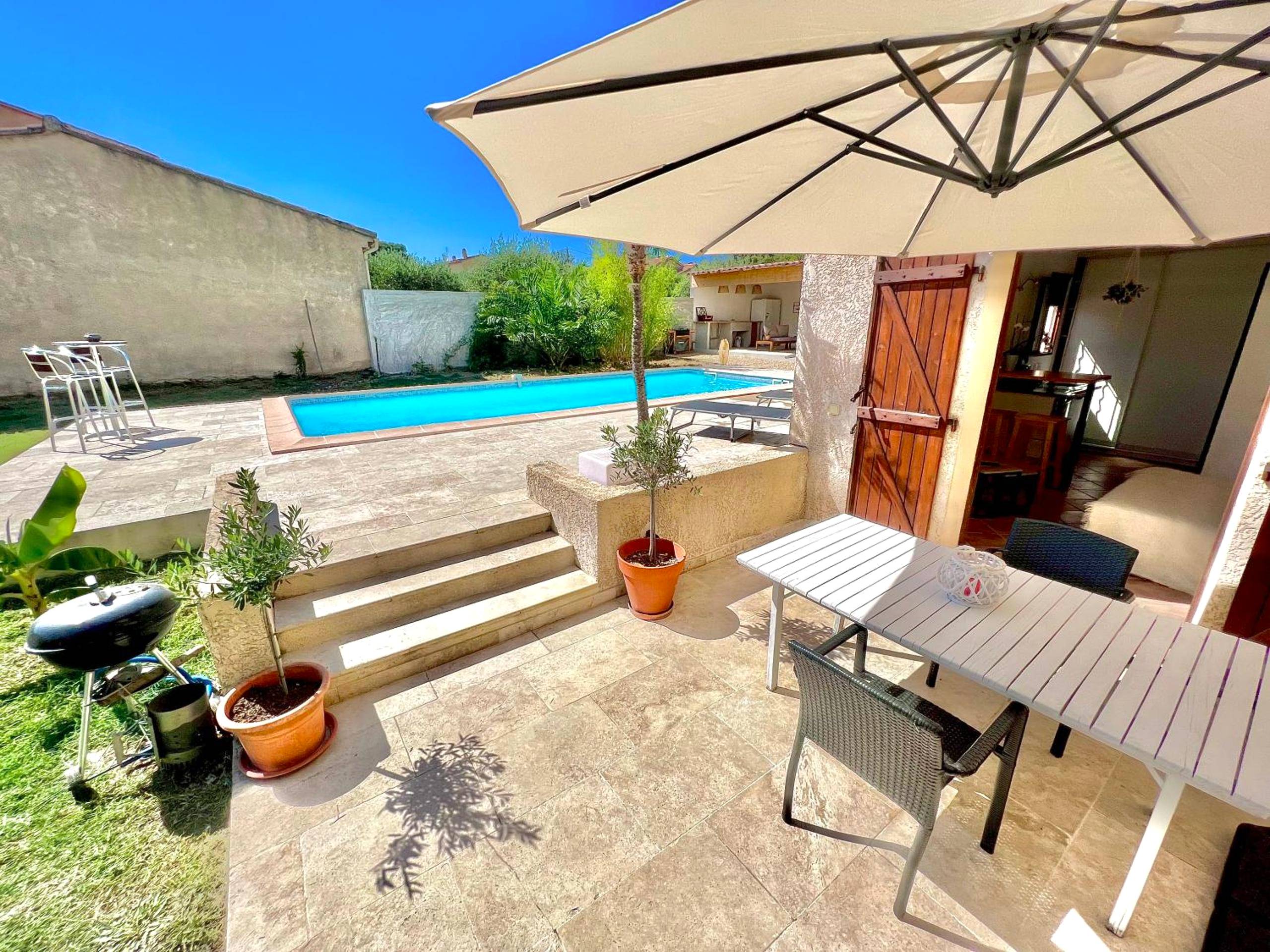 Terrasse aménagée avec table, parasol et piscine - Studio avec jacuzzi et piscine