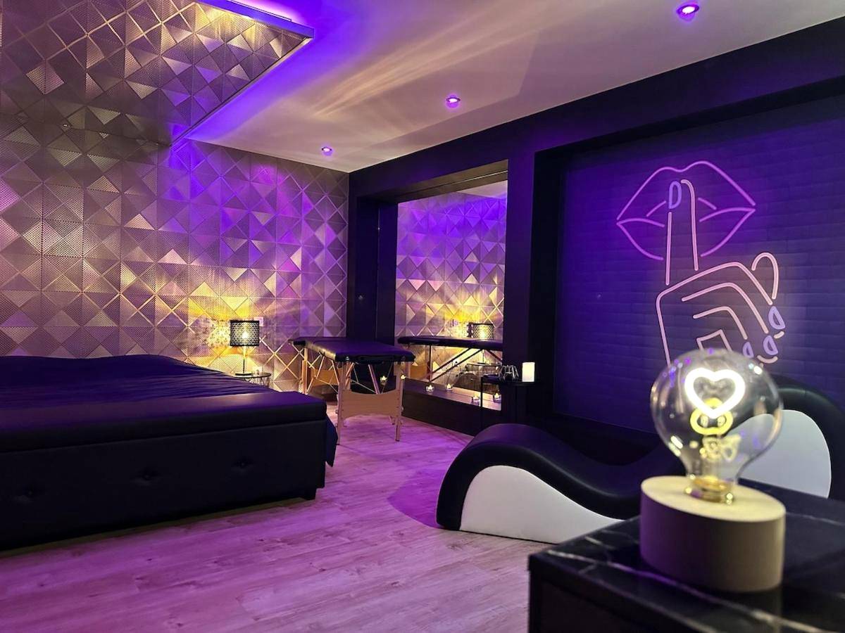 Chambre romantique avec néon mural et divan - Le studio secret