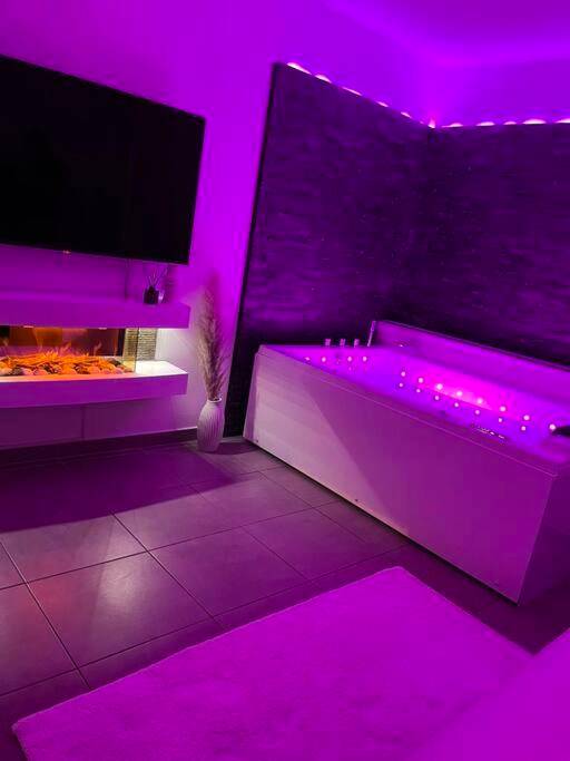Baignoire balnéo et cheminée avec éclairage néon - Love Room Castelnau - le - Lez - La suite
