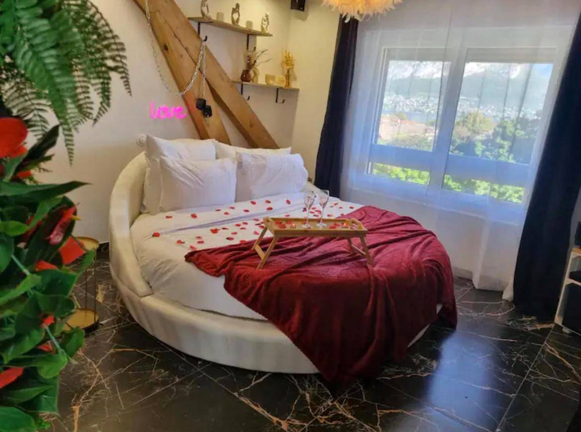 Lit rond avec pétales de rose et plateau - Love Room Sevrier - La Suite - Romantique Room