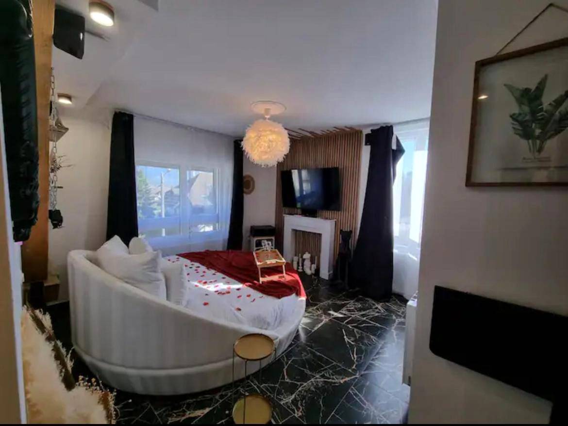 Chambre romantique avec lit rond et grand écran - La Suite - Romantique Room