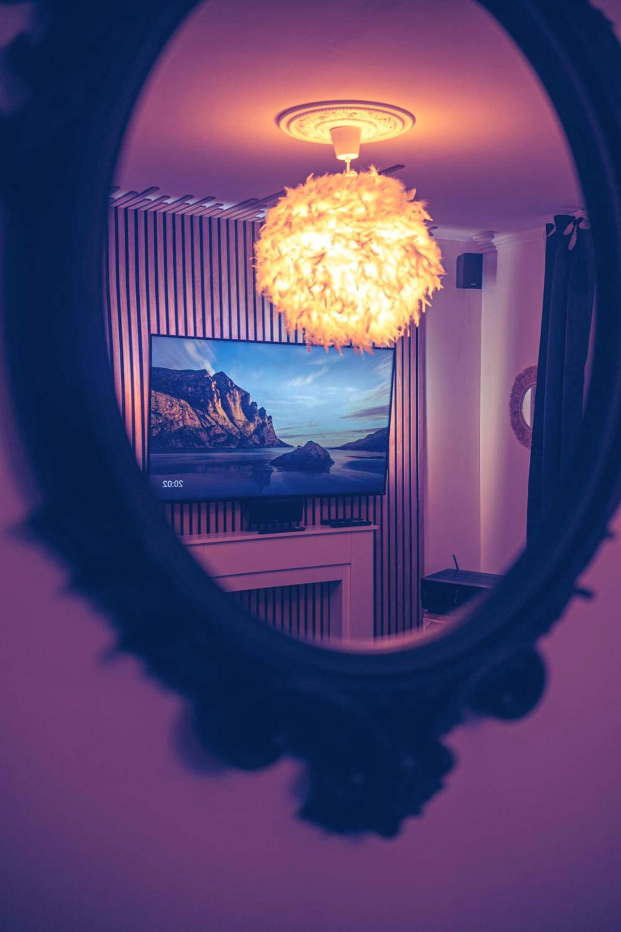 Reflet d'un lustre plume et écran dans un miroir - La Suite - Romantique Room
