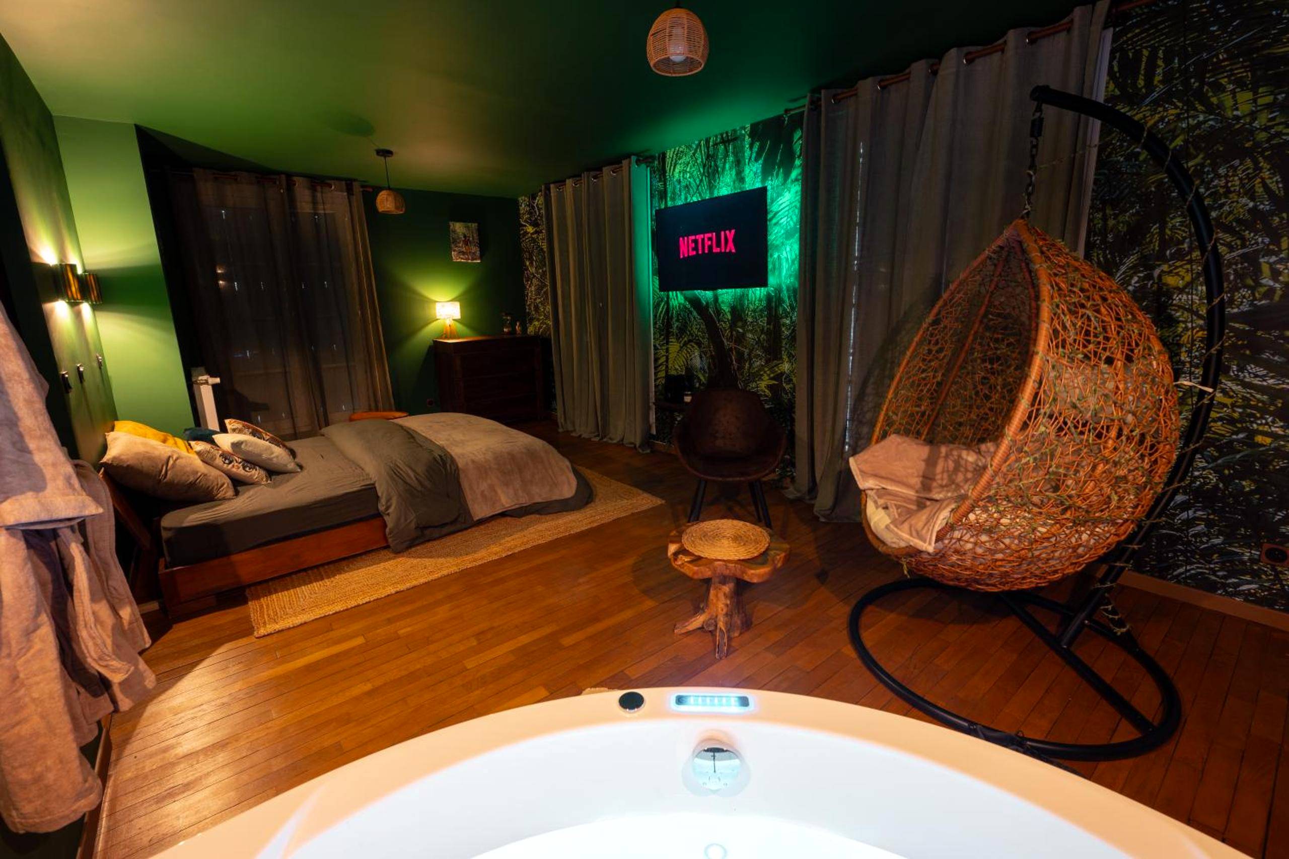Chambre avec lit double et fauteuil suspendu - Love Room Le Havre - Suite Amazonie de luxe avec balnéo