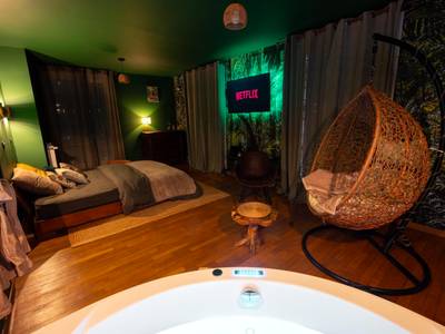 Chambre avec lit double et fauteuil suspendu - Love Room Le Havre - Suite Amazonie de luxe avec balnéo