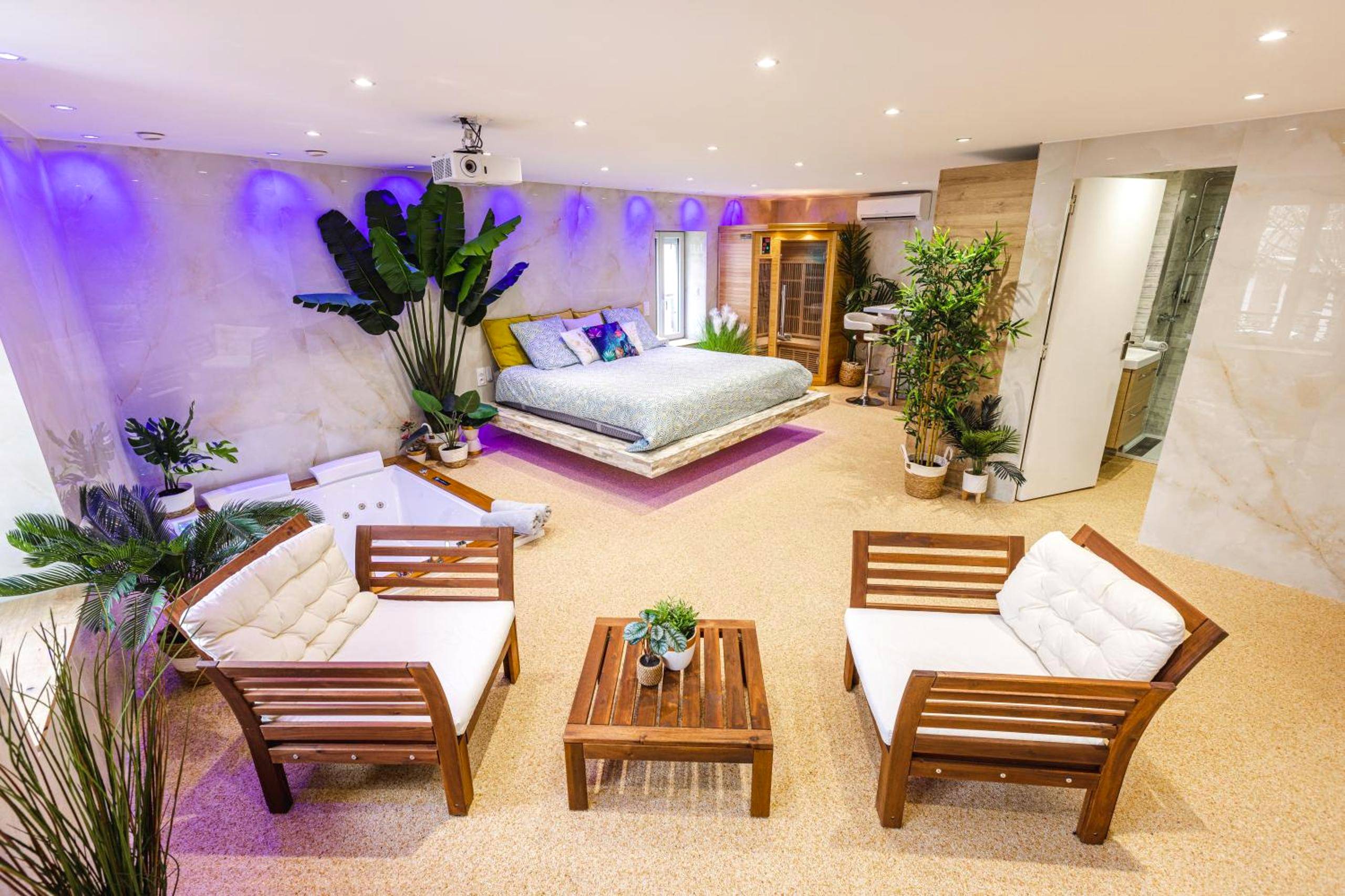 Espace salon avec fauteuils en bois et vue suite - La Suite d'Aubière