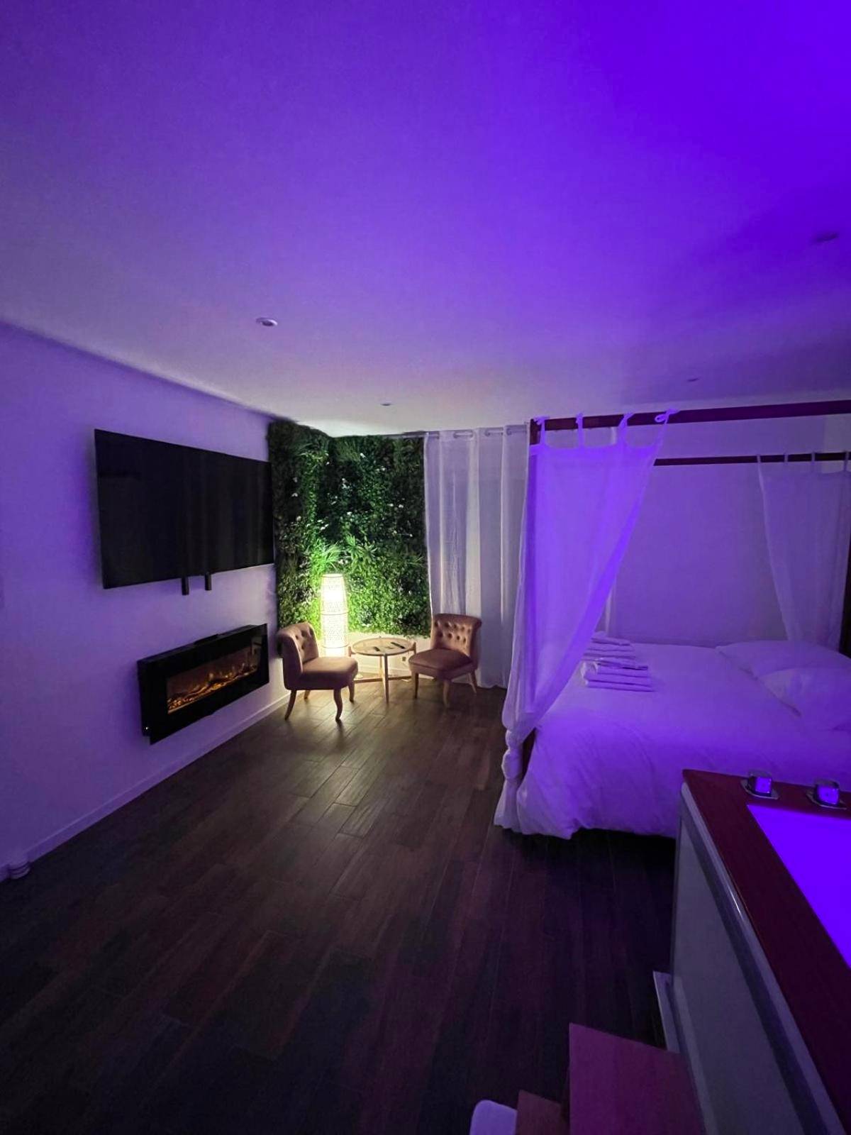Chambre romantique sous lumière tamisée violette - La Suite Bali Jacuzzi,Sauna,Netflix,Disney