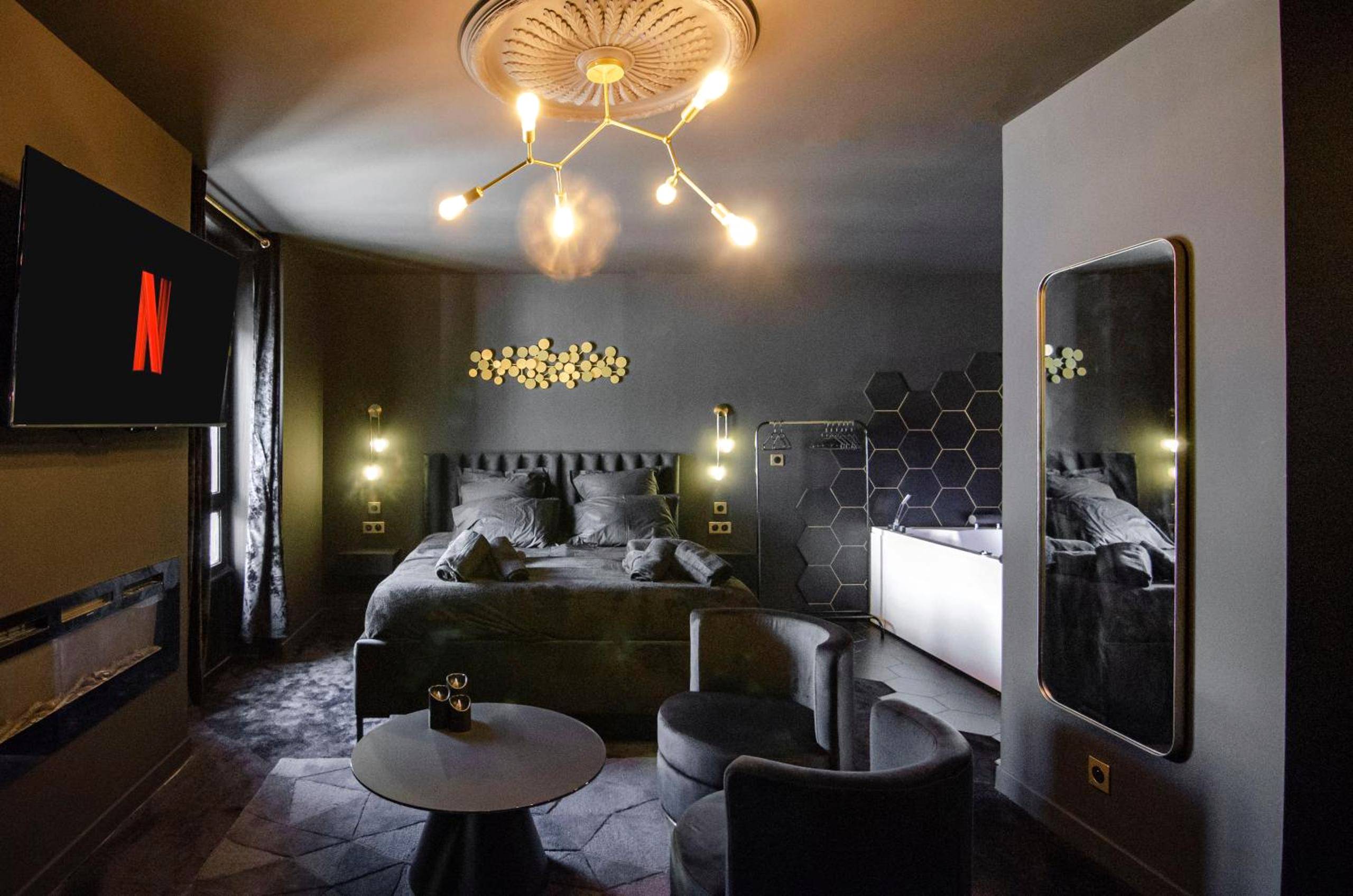 Chambre avec lit king size et jacuzzi - Love Room Saint - Étienne - Suite Balneo Hammam Noire et Or